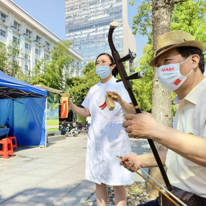 护士打起快板和居民共同演绎《快来采核酸》，号召市民配合扩面核酸筛查工作